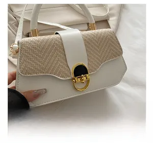 Détail du sac en cuir blanc et paille tressée avec élégant fermoir en métal doré en U