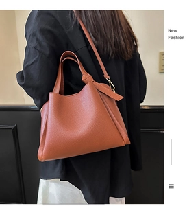 Sac à main en cuir marron porté par un mannequin montrant la taille et le style
