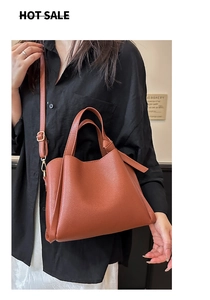 Détails de la texture du cuir synthétique grainé marron caramel sur ce sac seau de luxe