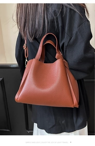 Sac cabas en cuir grainé marron porté par un mannequin en manteau noir, grande capacité