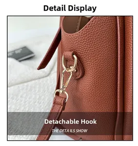 Gros plan du crochet doré amovible et du cuir grainé marron sur le sac à main