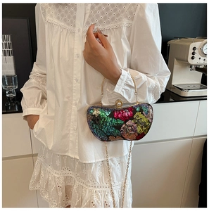 Détail du sac de soirée à paillettes colorées avec poignée dorée et fermoir perle sur mannequin