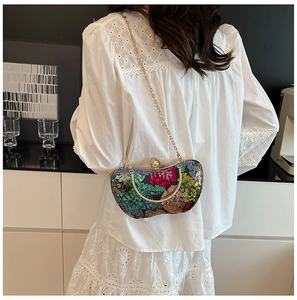 Détail de la pochette de soirée à paillettes avec chaîne dorée et fermoir en perle