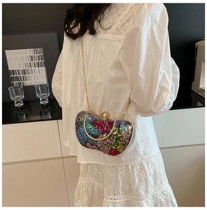 Détail du sac de soirée à paillettes colorées avec poignée en métal doré et fermoir perle