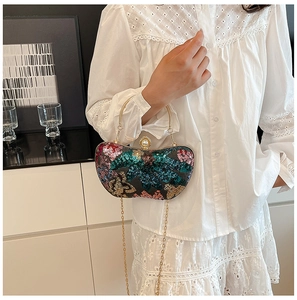 Détail du sac de soirée avec paillettes colorées, poignée dorée et accent de perle