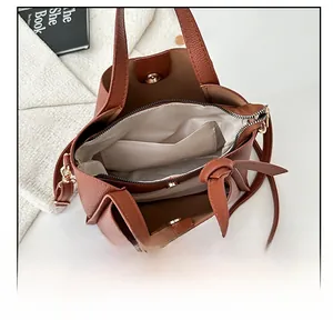 Vue intérieure du sac seau en cuir marron montrant sa grande capacité et ses compartiments