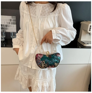 Détail du sac de soirée pailleté avec poignée dorée et fermoir perle élégant