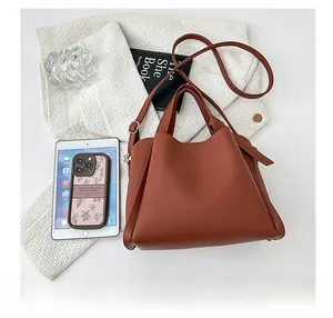 Sac fourre-tout en cuir marron grainé présenté avec un iPad pour montrer sa grande capacité