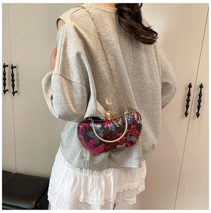 Détails d'un sac de soirée à paillettes avec poignée anneau dorée et bandoulière chaîne