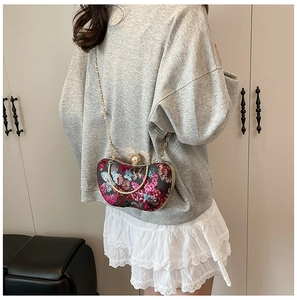 Détails des broderies à fleurs en paillettes et chaîne dorée sur la pochette de soirée