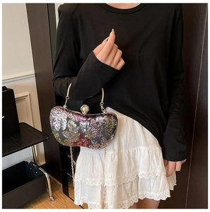 Détails de la broderie papillon en paillettes et du fermoir élégant avec perle décorative