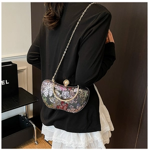 Détail de la pochette de soirée à paillettes avec chaîne dorée et fermoir chic