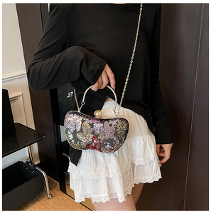 Détail d'un sac de soirée vintage à paillettes avec poignée dorée et fermoir en perle
