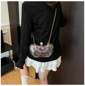 Mannequin portant un sac de soirée vintage à paillettes avec motif floral et chaîne dorée