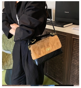 Close-up of quilted two-tone crossbody bag featuring gold twist lock and suede detail