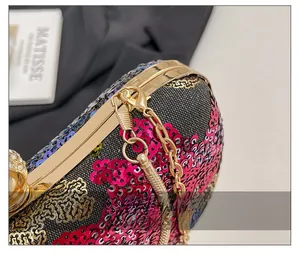 Gros plan de sequins multicolores sur sac de soirée avec fermoir perle et métal doré