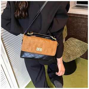 Detail of brown quilted matte crossbody bag featuring gold twist-lock and chain strap