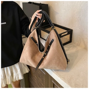 Détail du sac fourre-tout en daim avec lanières en cuir noir et boucles dorées