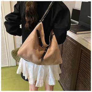 Détail du sac cabas en daim kaki avec lanières en cuir noir et boucles dorées rétro
