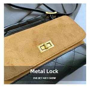Close-up of golden hardware rotation lock on quilted bicolor suede and leather handbag