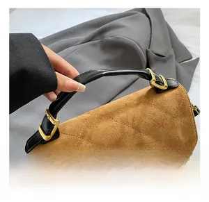 Detail of two-tone quilted leather handbag with gold buckle and frosted finish