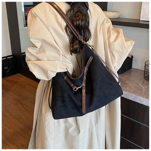 Détail de la bandoulière réglable en cuir et boucle métallique sur sac cabas noir en toile