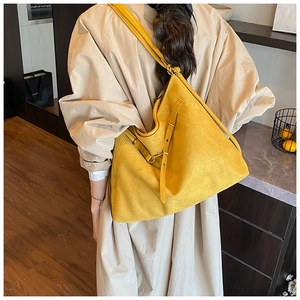 Détail macro du grand sac cabas jaune avec boucle décorative et texture en cuir souple