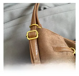 Détail de la bandoulière réglable avec boucle dorée sur un sac en cuir marron mat