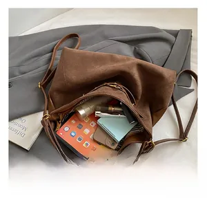 Vue intérieure montrant la grande capacité et la doublure rayée de ce sac cabas en daim