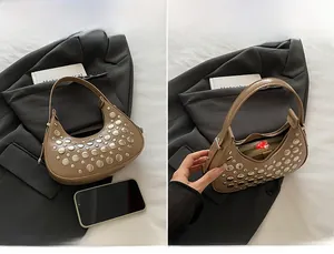 Detail view of khaki crescent rivet bag showing interior space and smooth PU leather