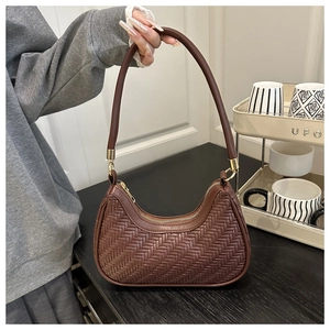 Vue détaillée du sac croissant marron avec texture tissée à chevrons et finitions dorées