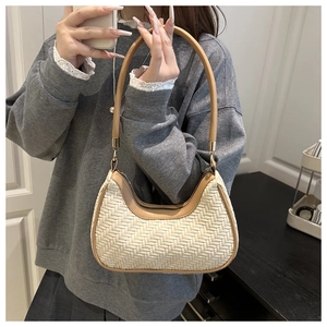 Détail du sac croissant tissé avec texture en fibre crème et garniture en cuir brun