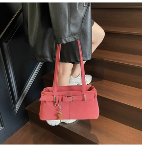 Detail of pink retro shoulder bag with matte leather texture and golden key pendant