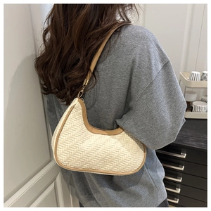 Dettaglio della borsa hobo intrecciata con finiture in pelle marrone e fibbia dorata
