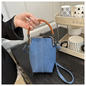 Détail d'un sac docteur en jean bleu avec fermoir métal et poignée cuir pour femme