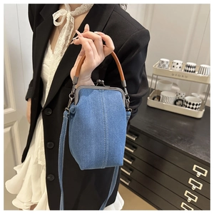 Détail du sac bandoulière en jean bleu avec fermoir rétro et poignée en cuir brun