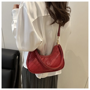 Détail du sac hobo tissé rouge montrant le motif chevrons et crochets dorés