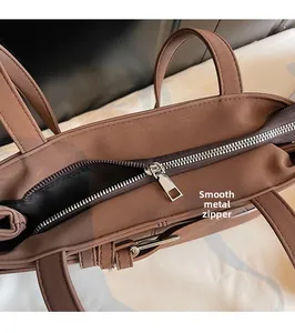 Macro detail of high-quality smooth silver metal zipper on vintage brown leather bag