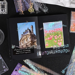 Music themed laser PET stickers with holographic notes and lace on a black notebook