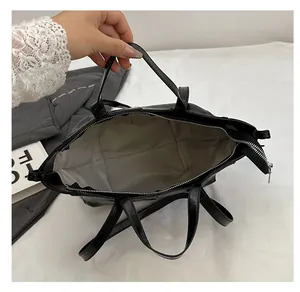 Top view of spacious black tote interior with light grey lining and zipper closure