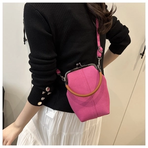 Detailed view of rose pink canvas shell bag with vintage metal clasp and top handle