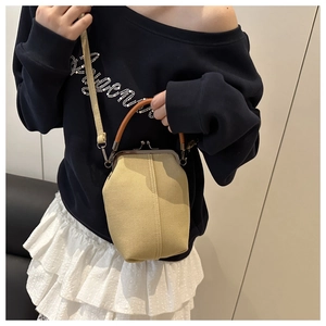Détail du sac coquillage en toile avec cadre métallique vintage et poignée marron chic