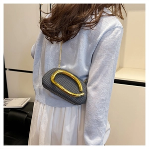 Detailansicht der runden grauen Web-Tasche mit großem Goldgriff an einem Modell