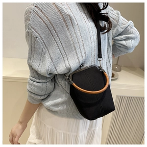 Détail du sac seau rétro en denim avec une anse ronde en bois et un fermoir métallique