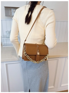Brown vintage leather crossbody bag with decorative gold chain and metal lock detail