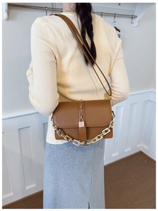 Detailed close-up of brown PU leather bag with golden chunky chain and metal lock accent