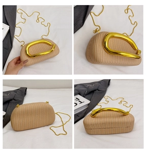 Detail der beige texturierten runden Clutch mit goldenem Metallgriff und Kettengurt
