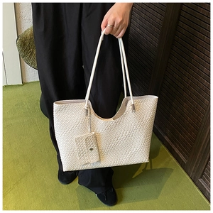 Close-up of white woven texture tote bag with matching small coin purse pendant