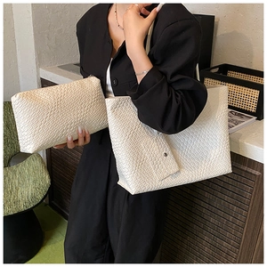 Close-up of beige woven texture tote bag and matching clutch set with a magnetic pouch