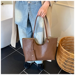 Close-up of brown woven tote bag with matching pouch and refined texture